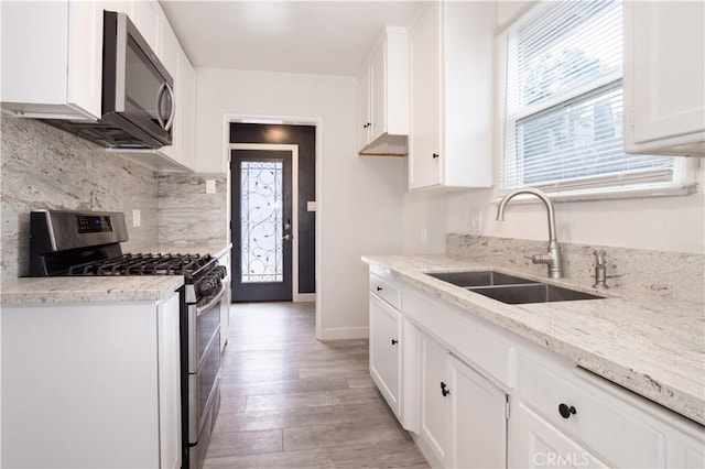 3035 Highridge Rd, La Crescenta, CA 91214 - kitchen with stainless steel appliances, a sink, white cabinetry, backsplash, and light stone countertops