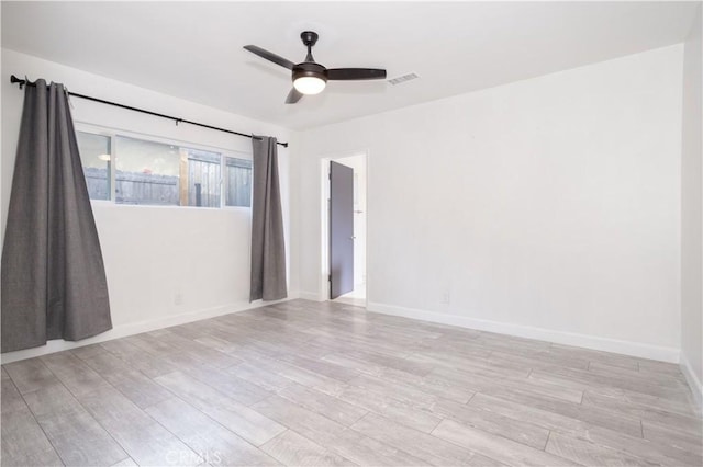 empty room with light wood-style floors, baseboards, and a ceiling fan