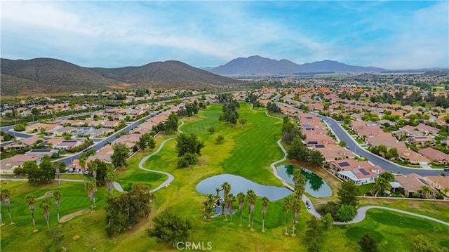 aerial view of property and surrounding area with nearby suburban area, a water and mountain view, and a local golf course