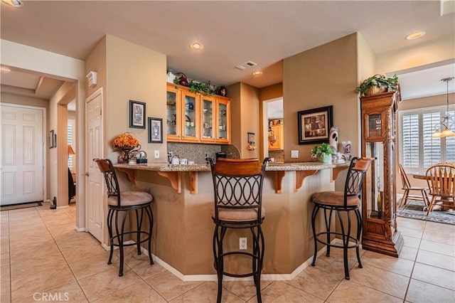 bar area featuring light tile patterned floors, tasteful backsplash, and recessed lighting
