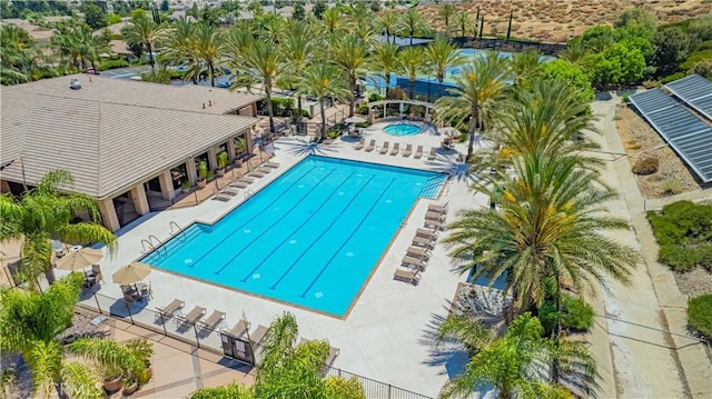 community pool with a patio area and a hot tub