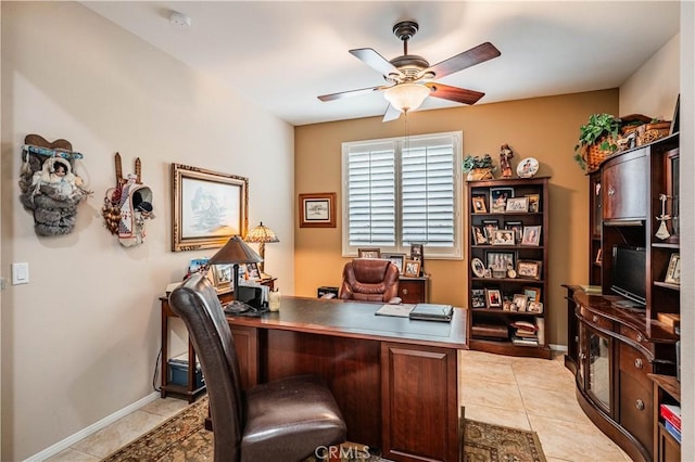 office space with ceiling fan, light tile patterned flooring, and baseboards