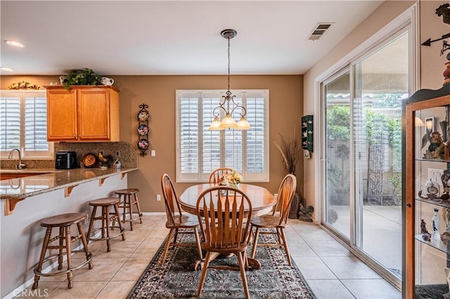 dining area featuring light tile patterned flooring, healthy amount of natural light, and baseboards