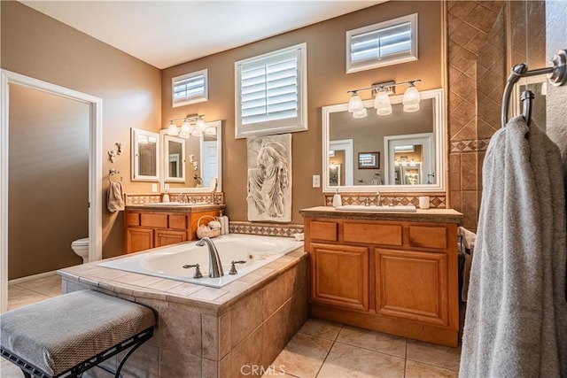 full bathroom featuring a garden tub, tile patterned flooring, toilet, and two vanities