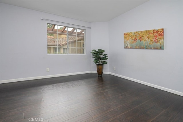 unfurnished room with dark wood-style flooring and baseboards