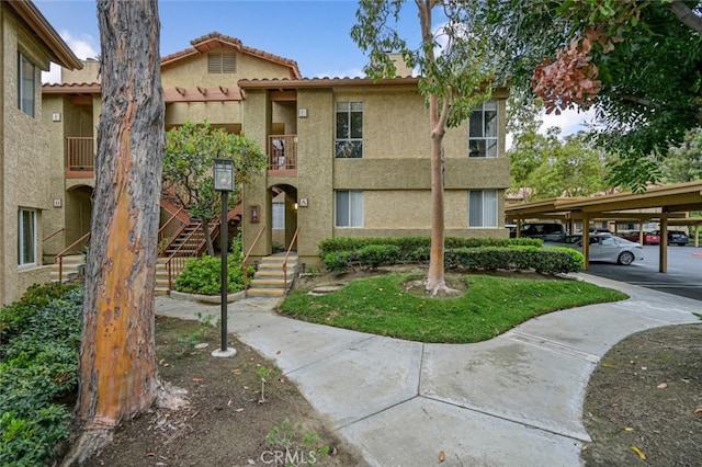 view of front of property with stucco siding and covered parking