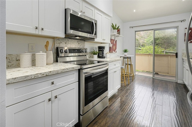 kitchen featuring stainless steel appliances, dark wood-type flooring, backsplash, white cabinets, and light stone counters