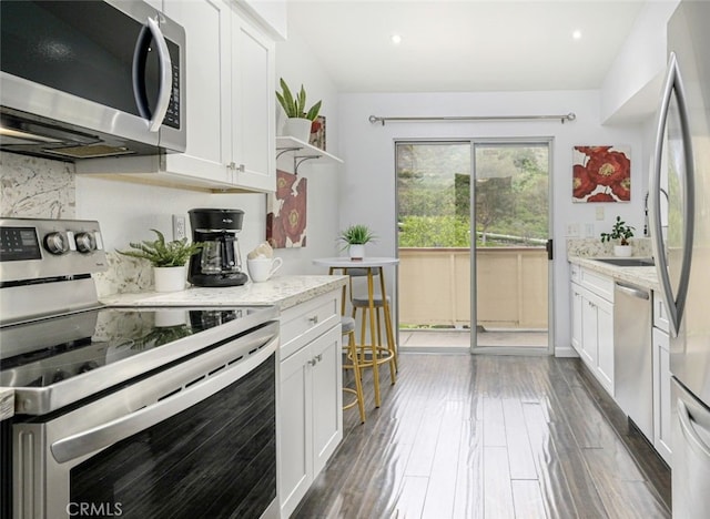 kitchen featuring stainless steel appliances, white cabinets, and recessed lighting