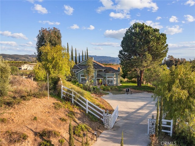 view of front of home with fence and a mountain view