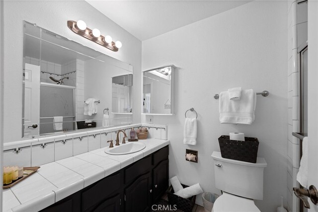 bathroom featuring a stall shower, toilet, and vanity