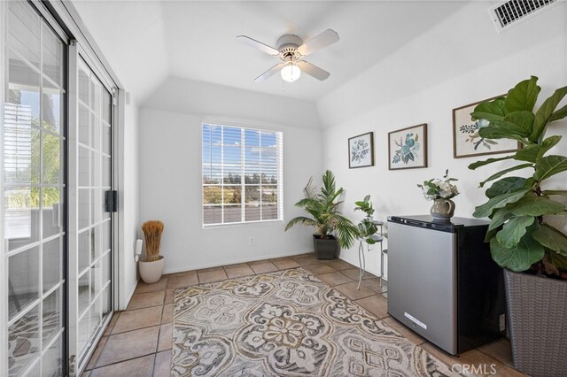 tiled home office with a ceiling fan and vaulted ceiling