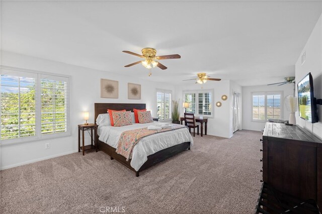 bedroom with light colored carpet, ceiling fan, and baseboards