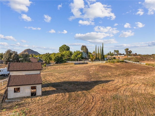 view of yard featuring fence, a mountain view, and an outbuilding
