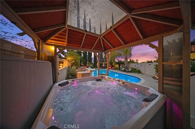 view of pool with a hot tub, a fenced backyard, and a patio area