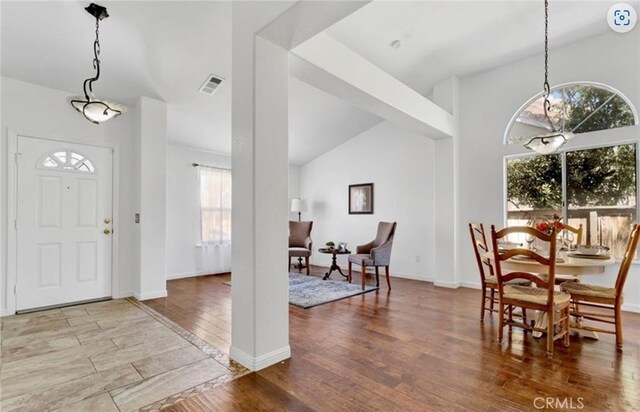 entrance foyer featuring wood finished floors, lofted ceiling, and baseboards