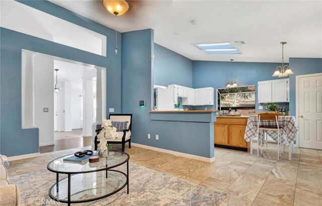 interior space with high vaulted ceiling, a chandelier, and baseboards