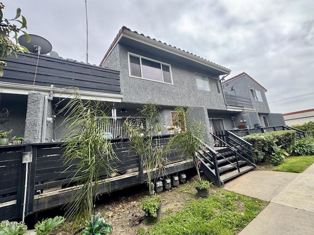 view of front facade featuring stucco siding and fence
