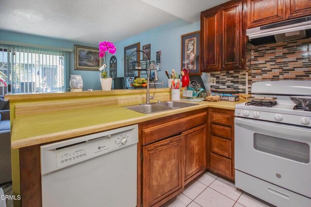 4578 Saviers Rd, Oxnard, CA 93033 - kitchen featuring white appliances, under cabinet range hood, backsplash, light countertops, and a peninsula