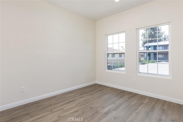spare room with light wood-type flooring and baseboards