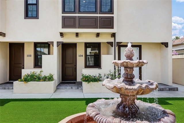 doorway to property featuring stucco siding