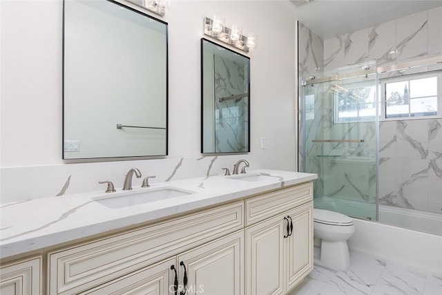 full bathroom featuring marble look tile flooring, toilet, double vanity, and bath / shower combo with glass door