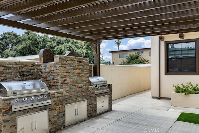 view of patio with grilling area, an outdoor kitchen, and a pergola