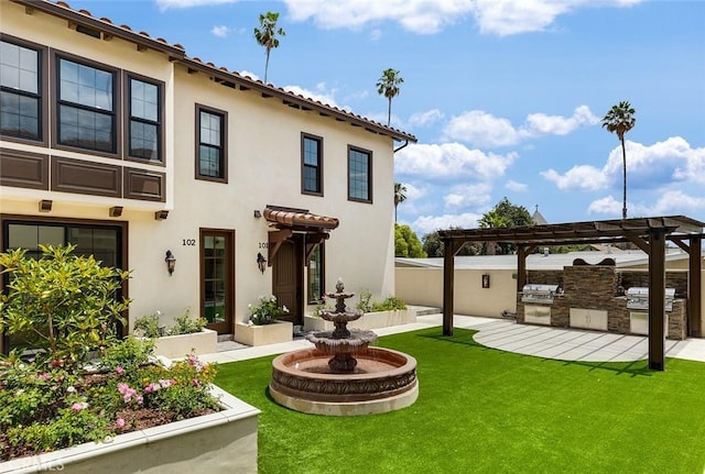 back of property with an outdoor kitchen, stucco siding, and a yard