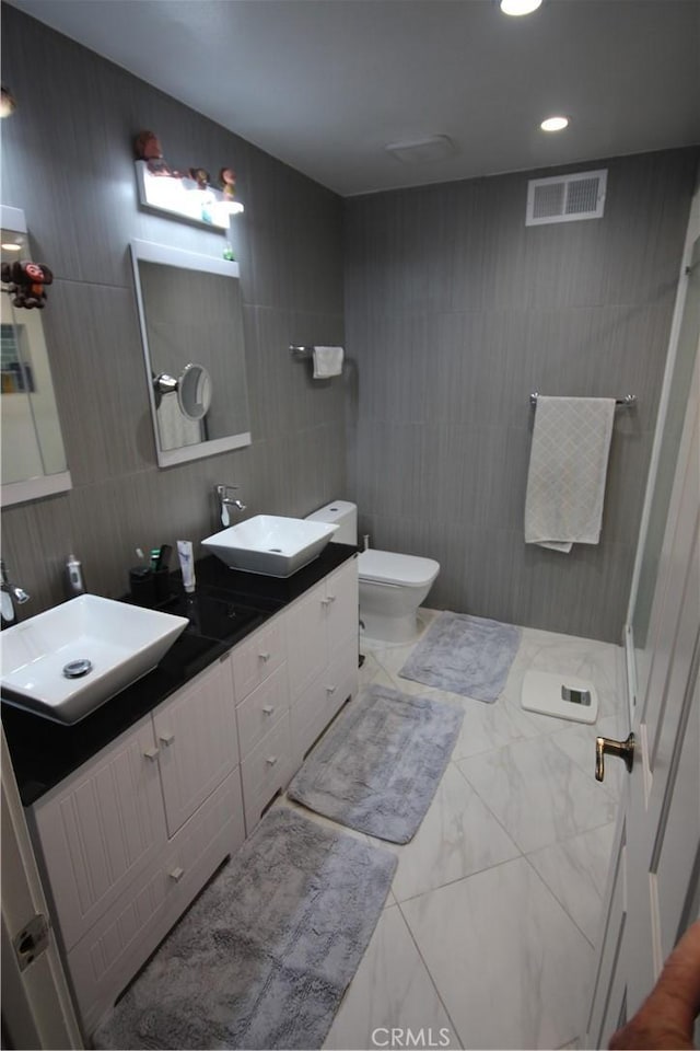 220 S Guadalupe Ave Unit 5, Redondo Beach, CA 90277 - bathroom featuring tile walls, marble look tiles, toilet, double vanity, and recessed lighting