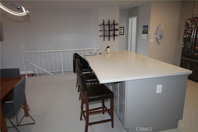 220 S Guadalupe Ave Unit 5, Redondo Beach, CA 90277 - kitchen featuring black fridge with ice dispenser, a breakfast bar area, an office area, light countertops, and gray cabinets