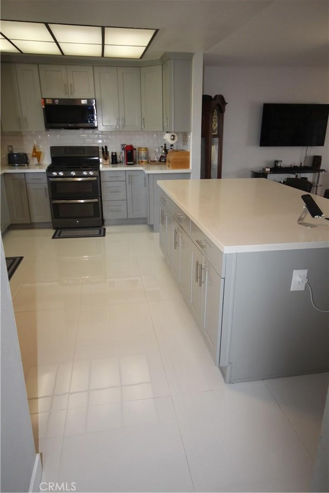 220 S Guadalupe Ave Unit 5, Redondo Beach, CA 90277 - kitchen featuring double oven range, gray cabinetry, stainless steel microwave, backsplash, and light countertops