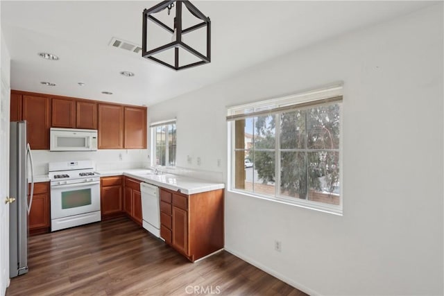 kitchen featuring white appliances, dark wood-style flooring, light countertops, baseboards, and brown cabinets