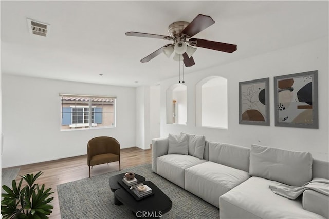living area with a ceiling fan and wood finished floors