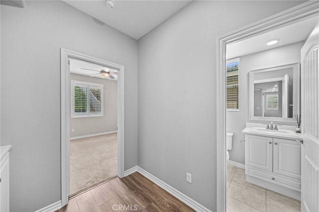 33378 Barmetta Ln, Temecula, CA 92592 - corridor featuring a sink, light wood-style flooring, and baseboards