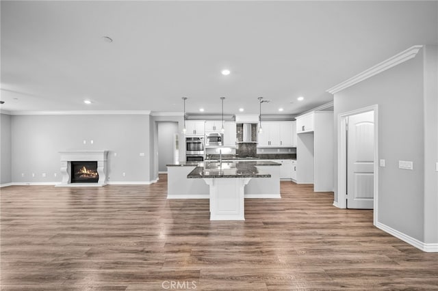 33378 Barmetta Ln, Temecula, CA 92592 - kitchen featuring wall chimney range hood, appliances with stainless steel finishes, recessed lighting, a center island with sink, and white cabinets