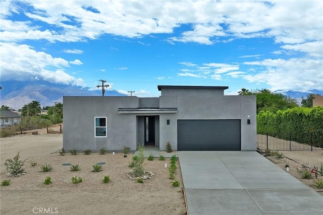 19187 Cottonwood Dr, Desert Hot Springs, CA 92241 - modern home with a garage, fence, a mountain view, driveway, and stucco siding