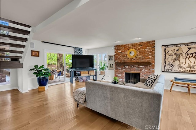 1475 Trenton Dr, Riverside, CA 92506 - living room with a brick fireplace, wood finished floors, baseboards, and stairway