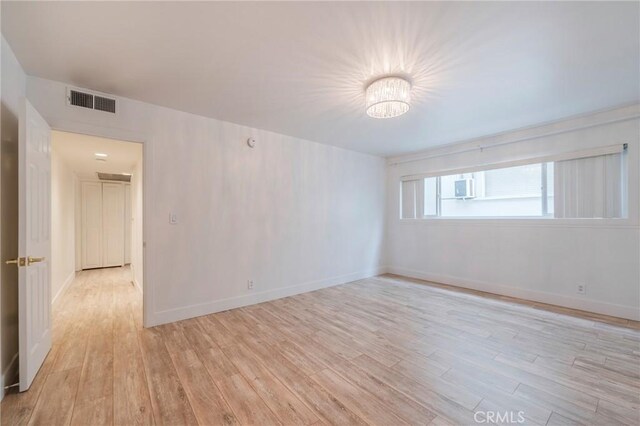 8963 Burton Way Unit 103, Los Angeles, CA 90048 - empty room with light wood-style floors, a chandelier, and baseboards