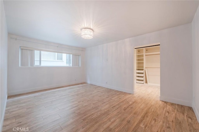 spare room with light wood-style flooring and baseboards