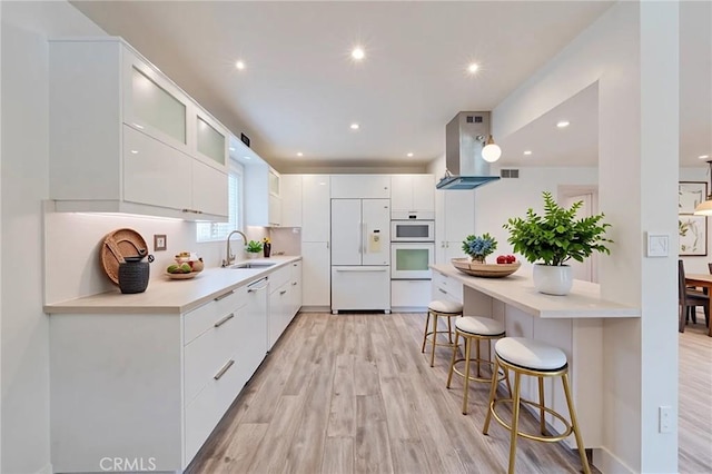 8963 Burton Way Unit 103, Los Angeles, CA 90048 - kitchen featuring built in fridge, modern cabinets, a breakfast bar, light wood finished floors, and recessed lighting