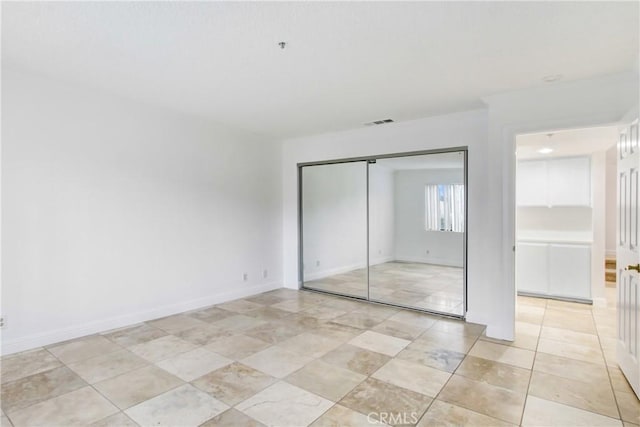 43195 Andrade Ave Unit A, Hemet, CA 92544 - unfurnished bedroom featuring a closet, light tile patterned floors, and baseboards