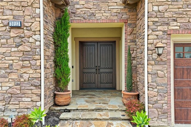 view of exterior entry featuring stone siding