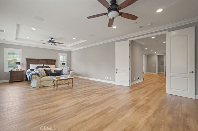 bedroom with light wood-type flooring, crown molding, recessed lighting, baseboards, and a raised ceiling