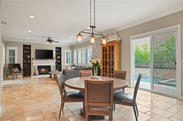 dining room featuring stone tile flooring, recessed lighting, a warm lit fireplace, ornamental molding, and ceiling fan