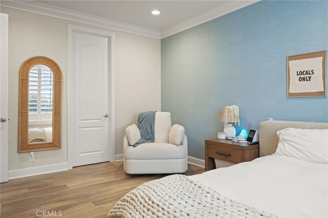 bedroom with wood finished floors, baseboards, ornamental molding, and recessed lighting