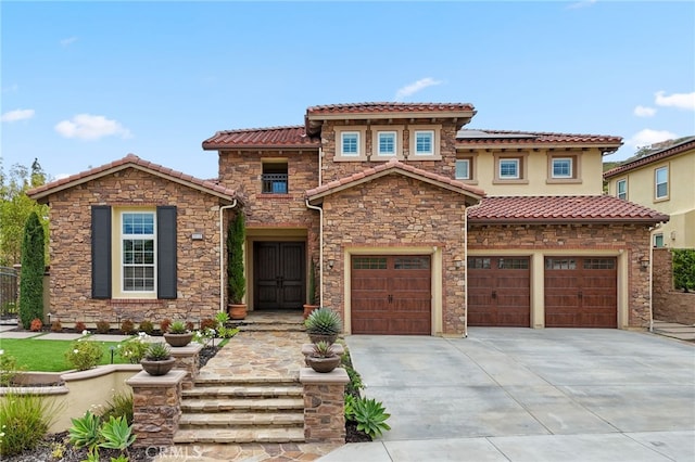 mediterranean / spanish-style house featuring driveway, a tile roof, an attached garage, solar panels, and stone siding