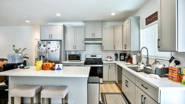 13611 Glenhaven Dr, Garden Grove, CA 92843 - kitchen with appliances with stainless steel finishes, a sink, a breakfast bar area, decorative backsplash, and recessed lighting