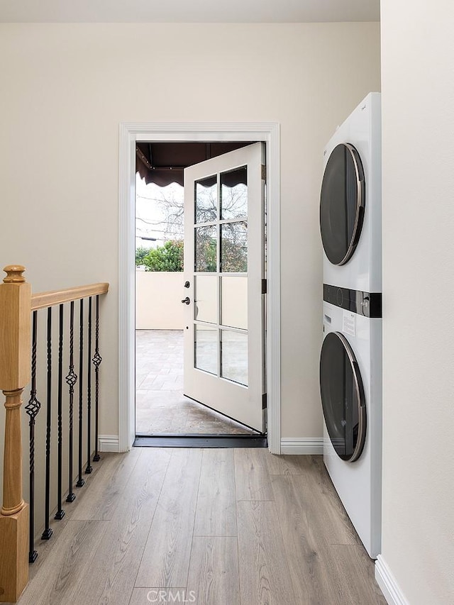 81 N Grand Oaks Ave Unit 102, Pasadena, CA 91107 - laundry area with stacked washing machine and dryer, light wood finished floors, and baseboards