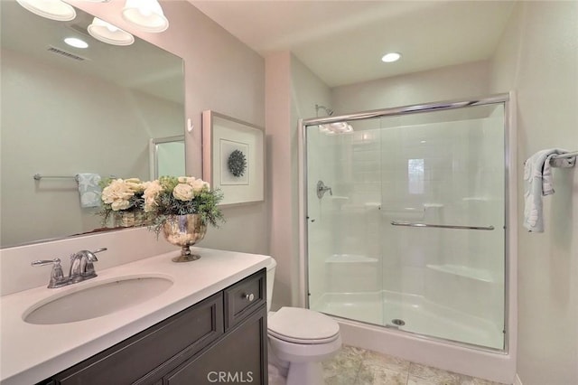 bathroom with a stall shower, toilet, vanity, and recessed lighting