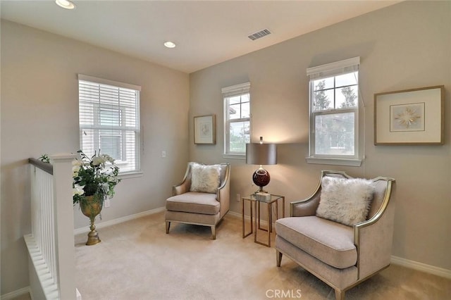living area with healthy amount of natural light, light carpet, baseboards, and recessed lighting