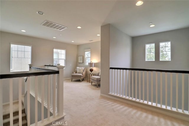 sitting room with an upstairs landing, recessed lighting, carpet, and baseboards